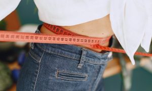 Женщина измеряет талию