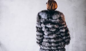 Женщина в шубе спиной