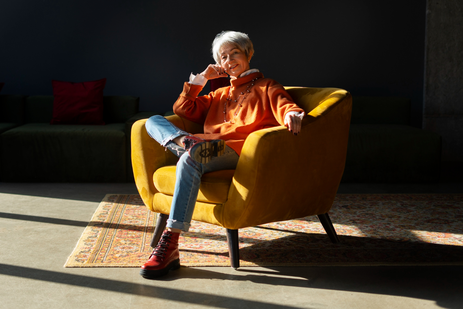 Женщина улыбается, сидя в кресле