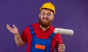 Ремонтник с валиком и в каске сомневается