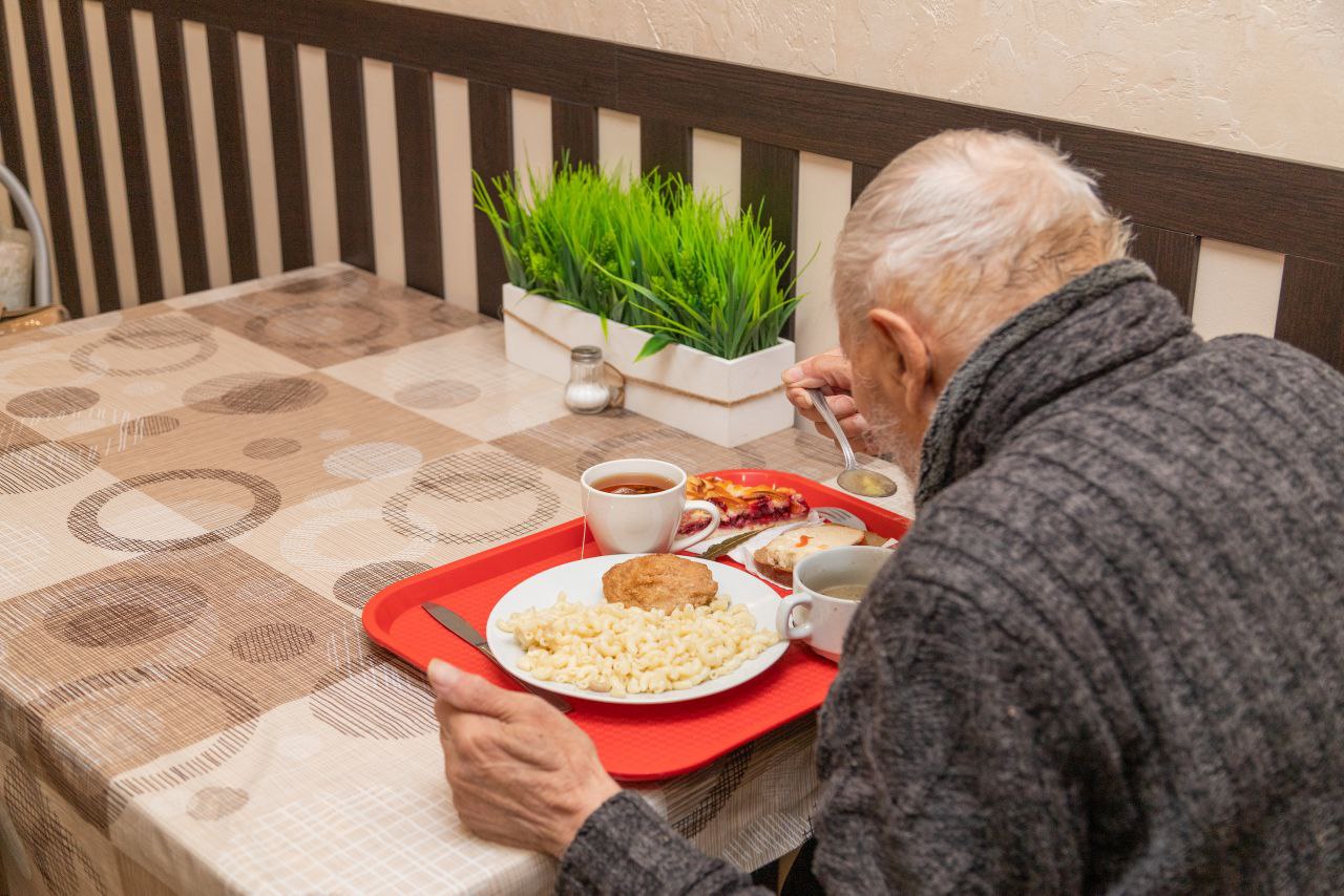 Пожилой мужчина ест