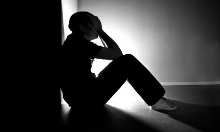 человек на полу сжимает голову