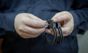 Человек держит наручники