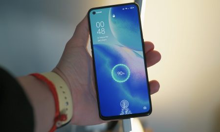 Рука держит телефон на зарядке