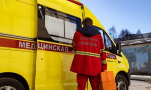 Медик стоит у автомобиля скорой помощи