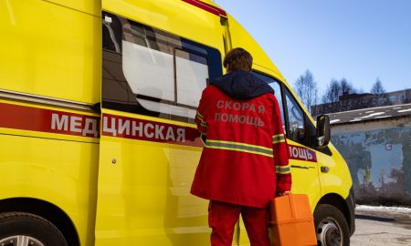 Медик стоит у автомобиля скорой помощи