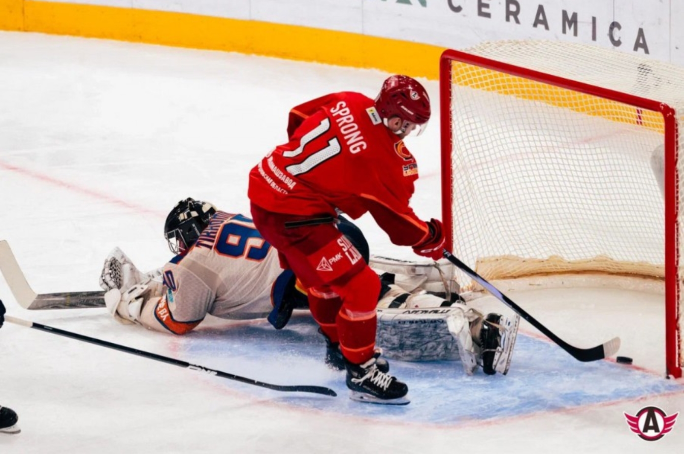 хоккеист "Автомобилиста" забивает шайбу в ворота "Шанхайских драконов"