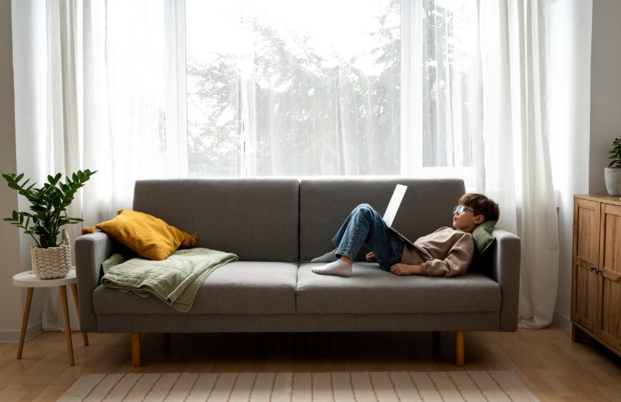 мальчик смотрит мультфильмы на диване