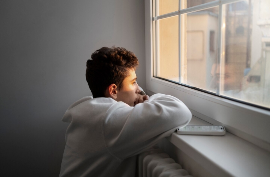 парень смотрит в окно