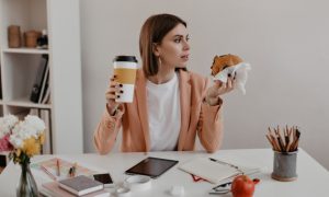 девушка перекусывает в офисе