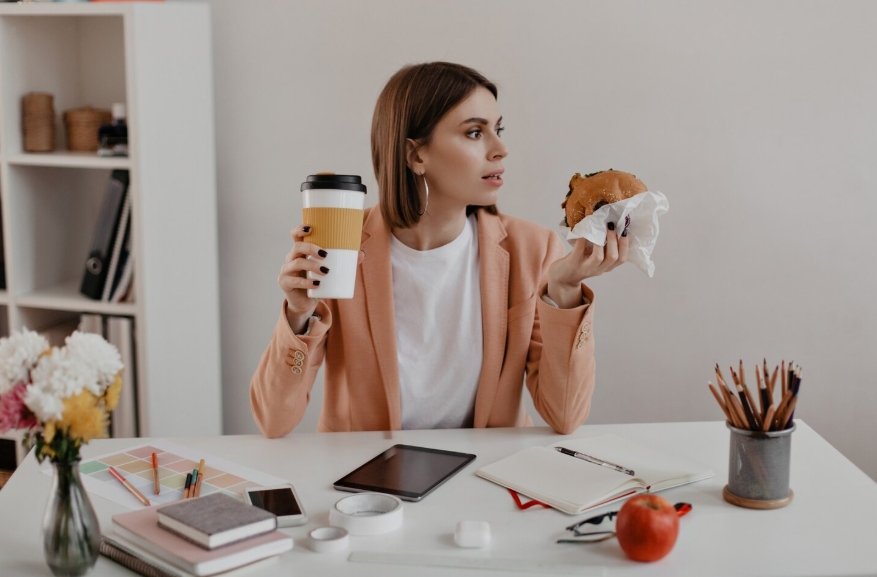 девушка перекусывает в офисе