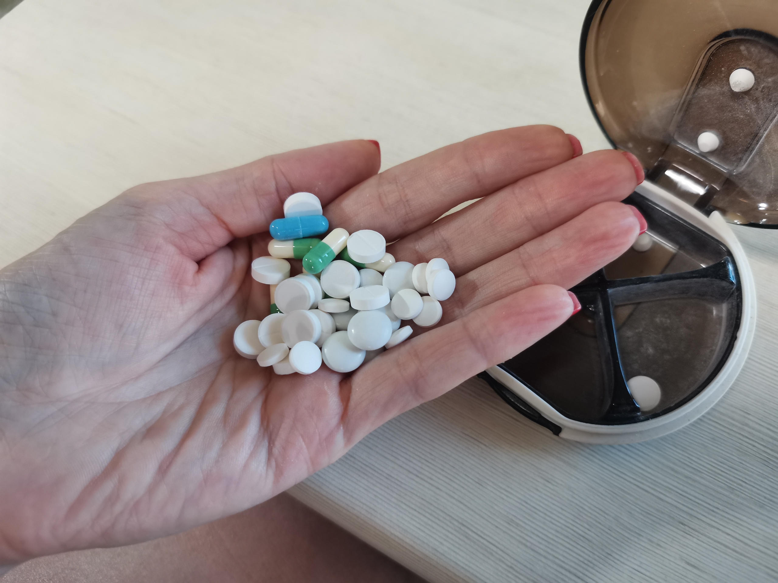 Женщина держит таблетки