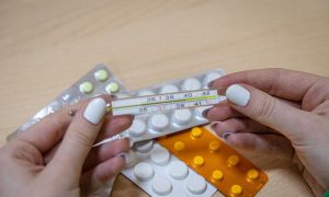 Девушка держит градусник