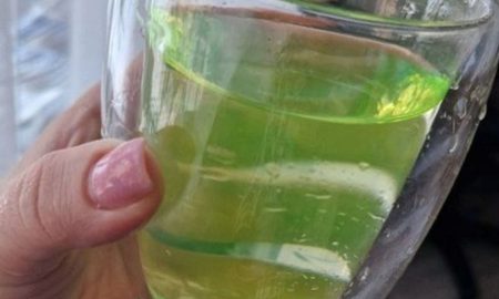 Женщина держит стакан с водой