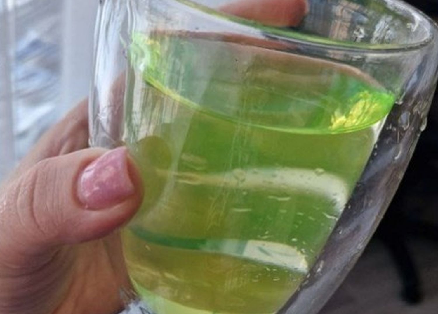 Женщина держит стакан с водой