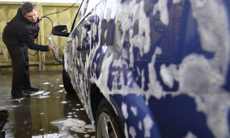 Мужчина моет машину