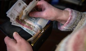 Бабушка держит в руках пенсию