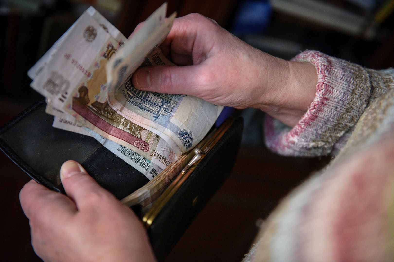 Бабушка держит в руках пенсию