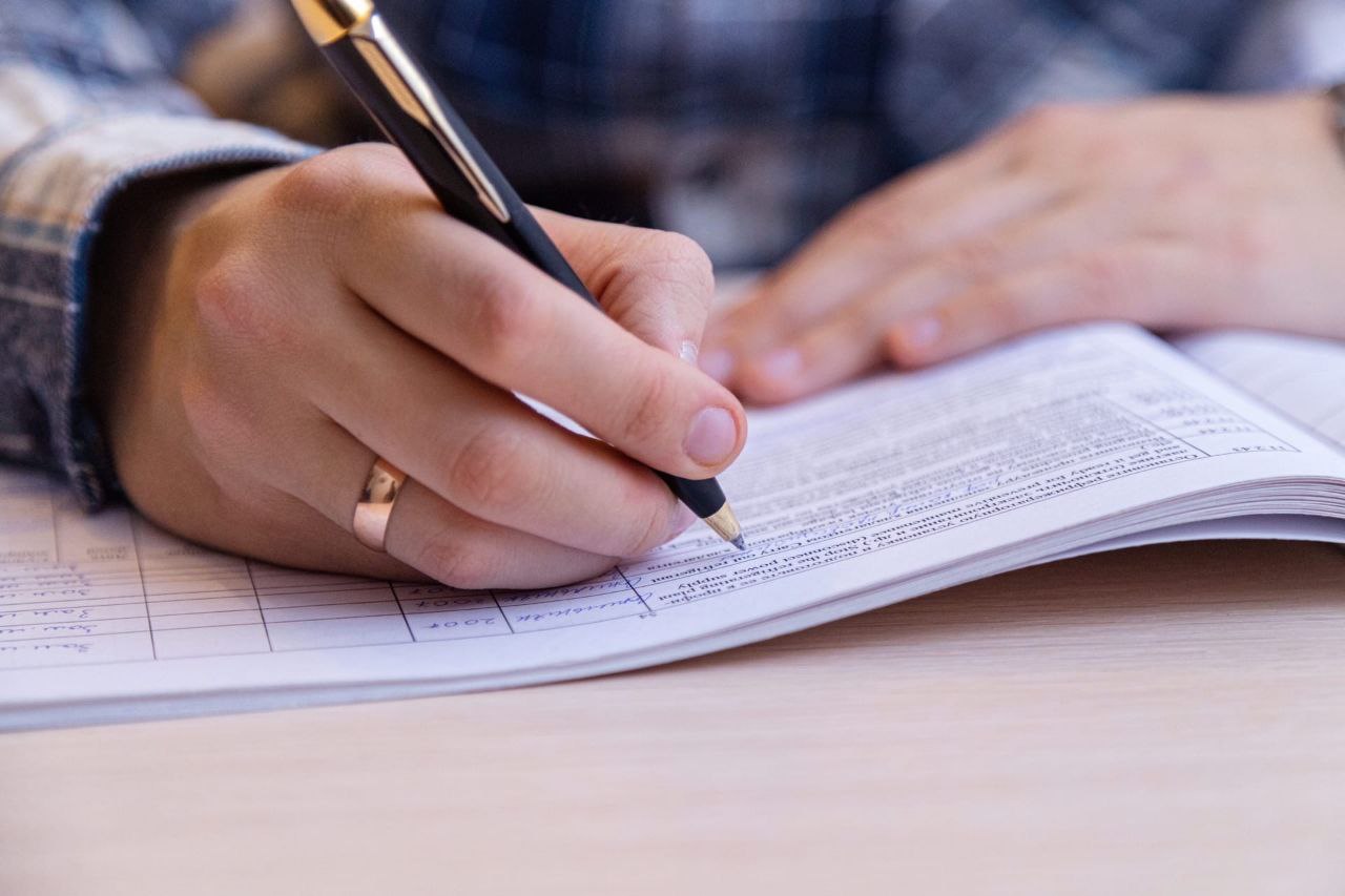 Человек подписывает документ