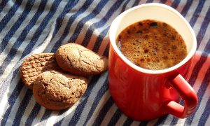 У кружки с кофе лежит печенье