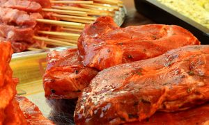 На доске лежит маринованное мясо