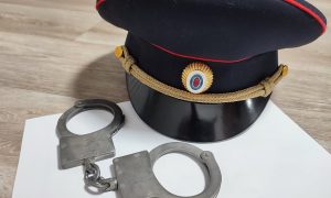 Фуражка и наручники на столе