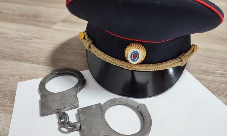 Фуражка и наручники на столе