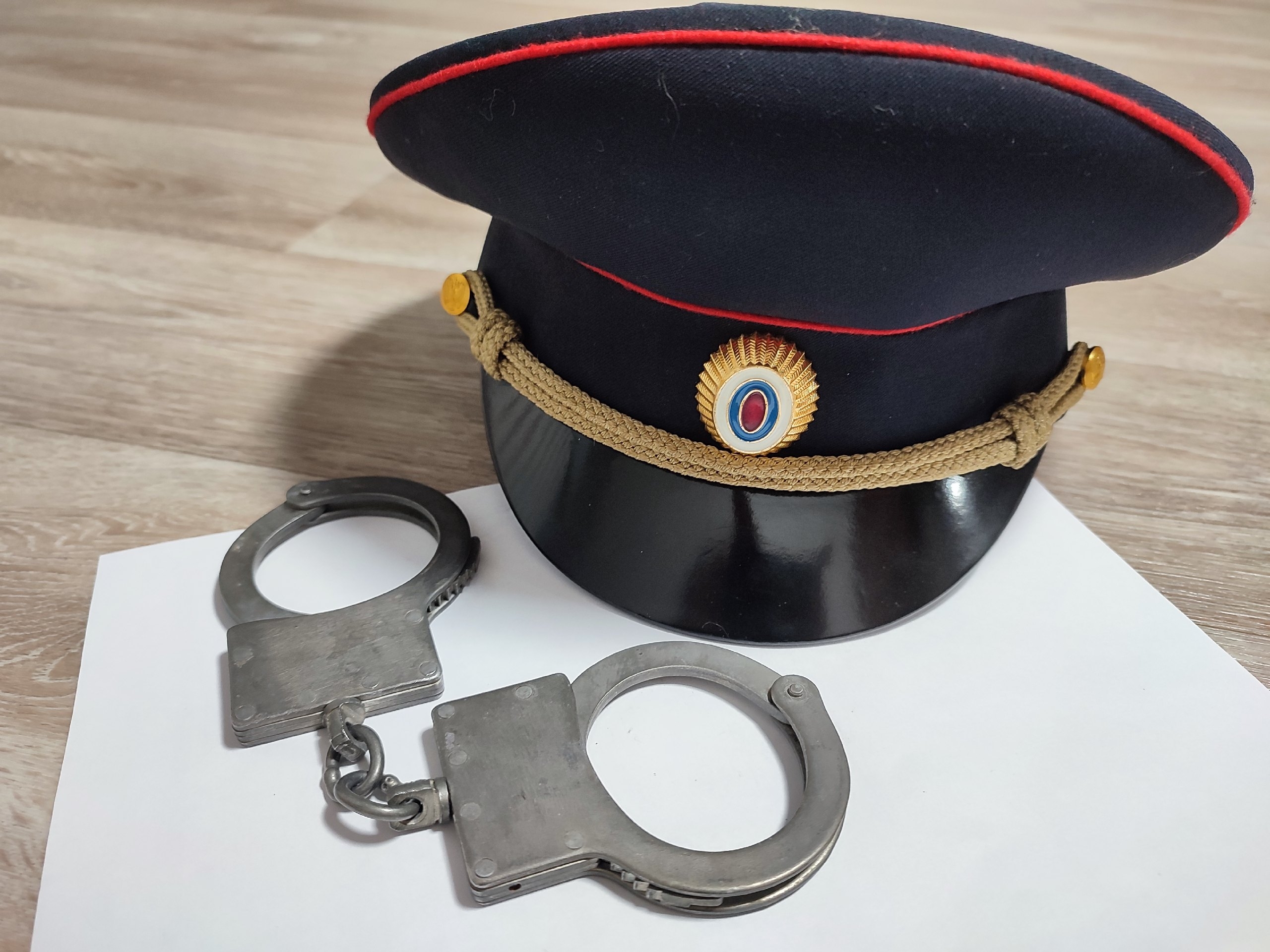 Фуражка и наручники на столе