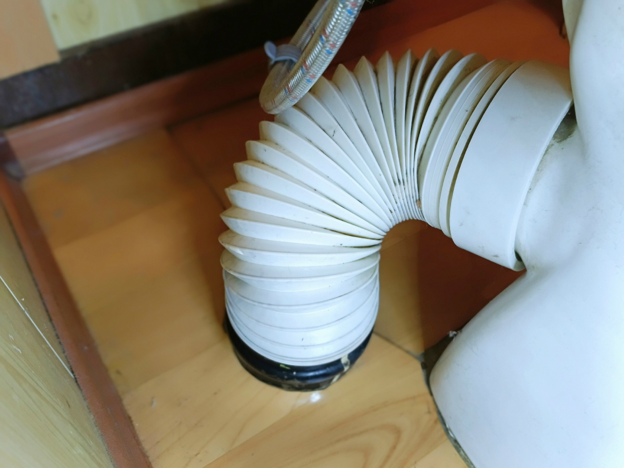 На унитазе белая гофра