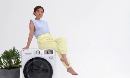 ухоженная женщина на стиральной машинке