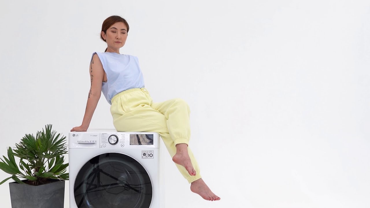 ухоженная женщина на стиральной машинке