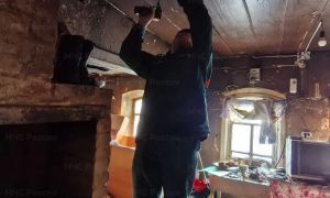 Сотрудник МЧС устанавливает извещатель