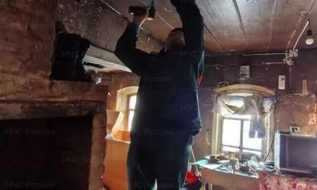 Сотрудник МЧС устанавливает извещатель