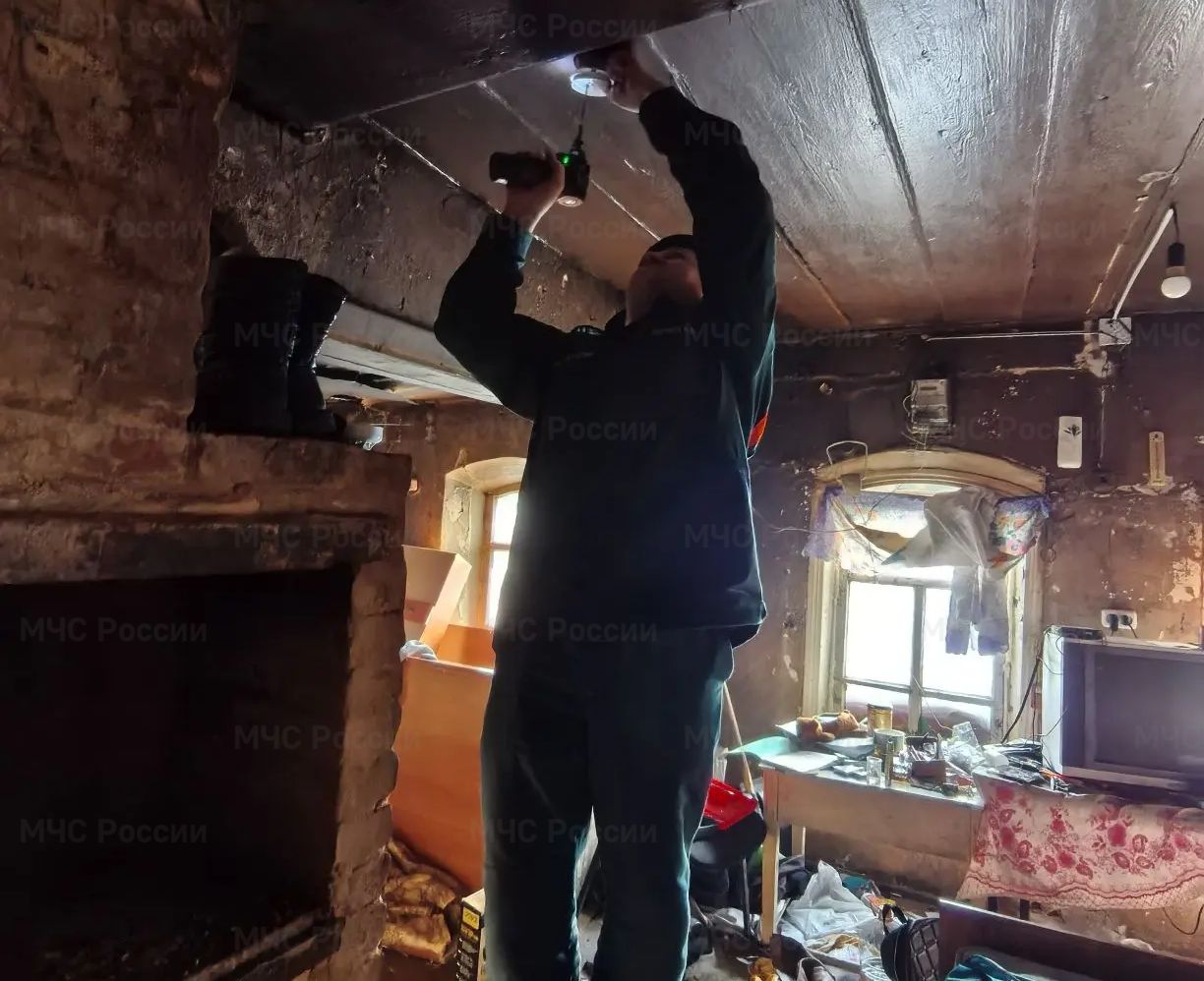 Сотрудник МЧС устанавливает извещатель