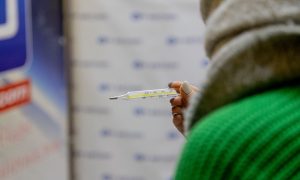 Девушка держит градусник