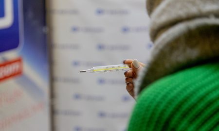 Девушка держит градусник