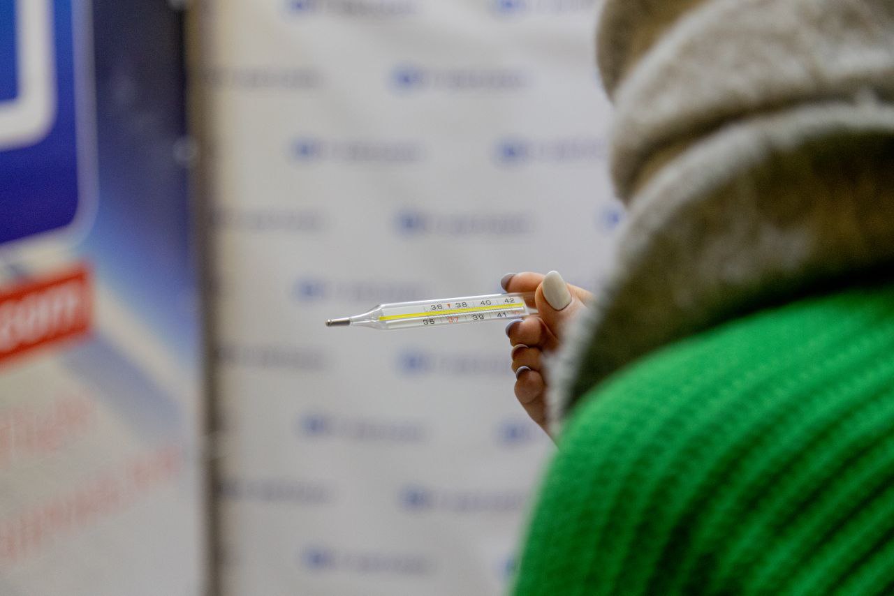 Девушка держит градусник