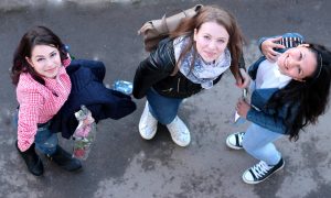 Три девушки смотрят в камеру снизу вверх.