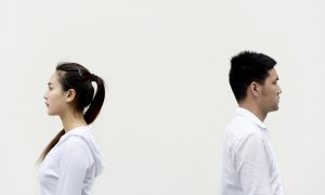 Мужчина и женщина в белой одежде стоят, отвернувшись друг от друга