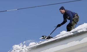 Убирают снег с крыши