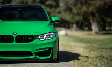 На дороге стоит зеленый автомобиль