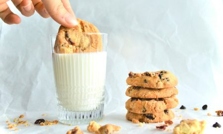 Женщина макает печенье в стакан молока