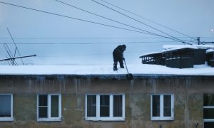 Мужчина убирает снег