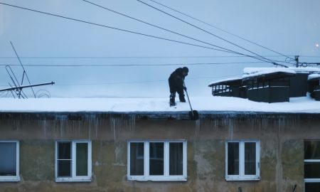 Мужчина убирает снег