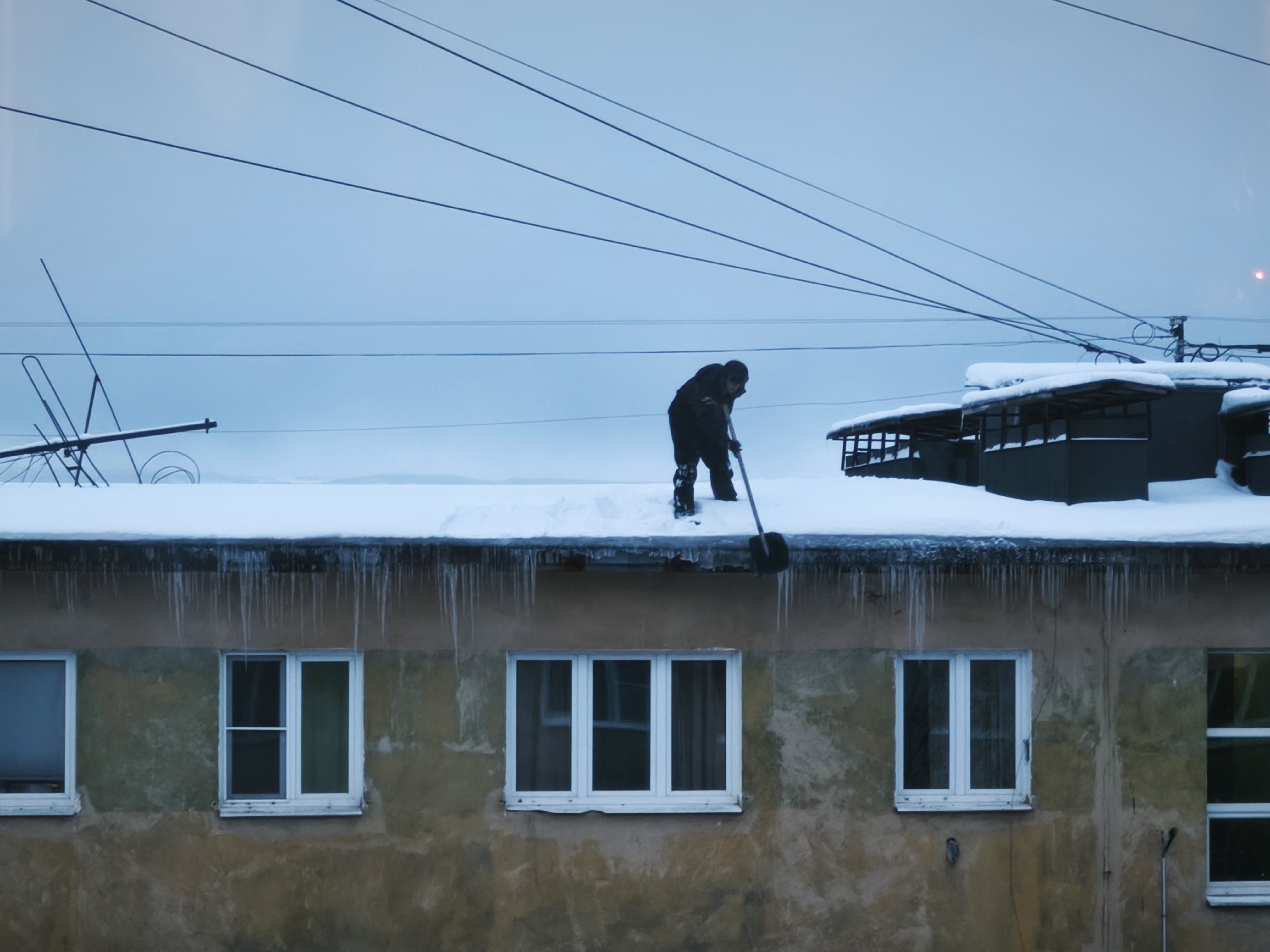 Мужчина убирает снег