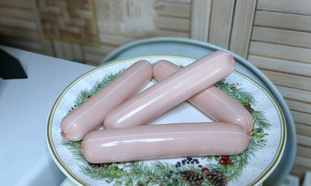 На тарелке лежат сосиски.