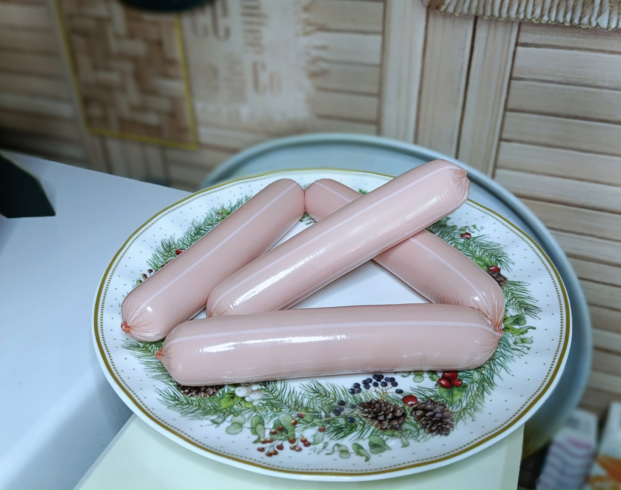 На тарелке лежат сосиски.