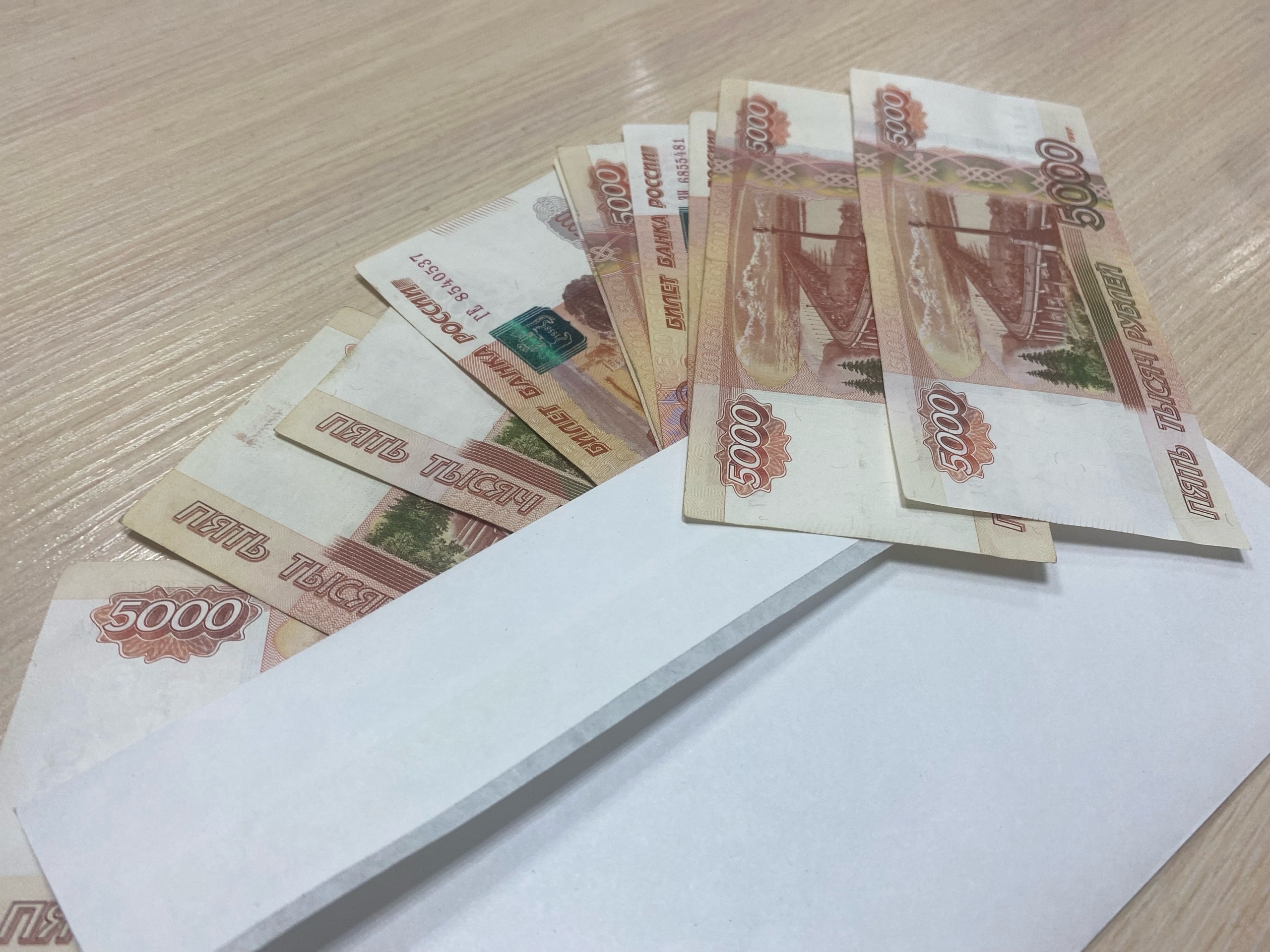 Деньги в конверте на столе