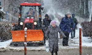 Люди идут по одной из улиц во время снегопада.