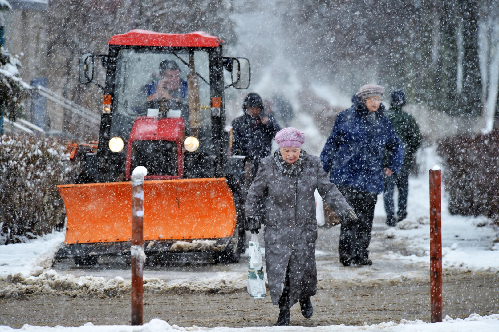 Люди идут по одной из улиц во время снегопада.